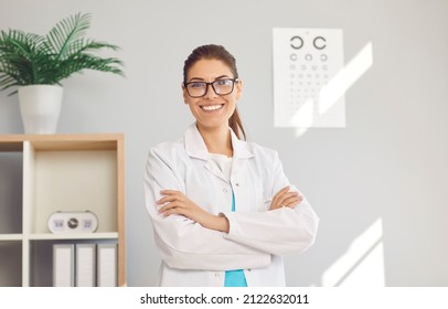 Portrait of happy young Caucasian female optician in white medical uniform pose in optics salon. Smiling woman doctor in private clinic or hospital. Eyesight correction. Healthcare, sight problem.