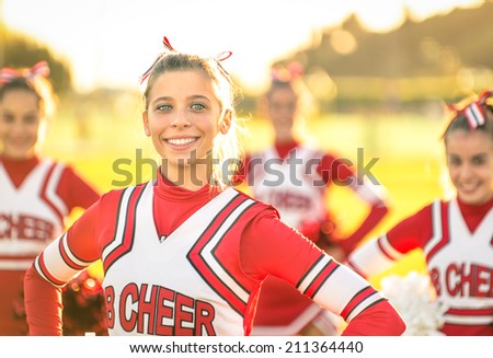 Portrait of an happy young cheerleader in action outdoors - Group of girlfriends during cheerleading sport training at high school