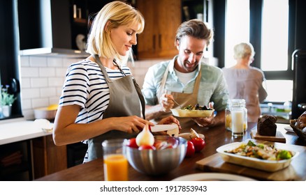 Portrait of happy young couple cooking together in the kitchen at home.