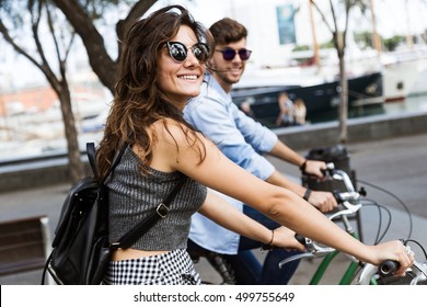 Portrait Of Happy Young Couple Cycling In The City.