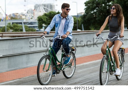 Portrait of happy young couple cycling in the city.