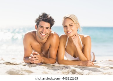Portrait of happy young couple lying on beach