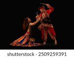 Portrait of happy young couple performing Dandiya Raas during Navratri celebration