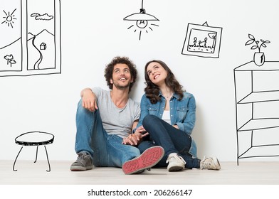 Portrait Of Happy Young Couple Sitting On Floor Looking Up While Dreaming Their New Home And Furnishing - Shutterstock ID 206266147