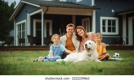Portrait of a Happy Young Family Couple with a Son and Daughter, and a Noble White Golden Retriever Dog Sitting on a Grass in Their Front Yard at Home. Cheerful People Looking at Camera and Smiling. - Powered by Shutterstock