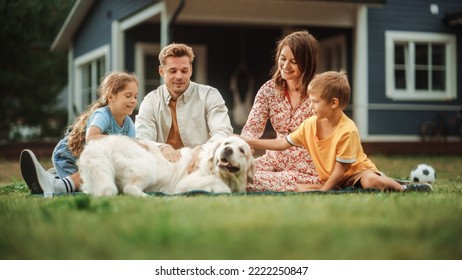 Portrait of a Happy Young Family Couple with a Son and Daughter, and a Noble White Golden Retriever Dog Sitting on a Grass in Their Front Yard at Home. Cheerful People Petting the Dog and Smiling. - Powered by Shutterstock