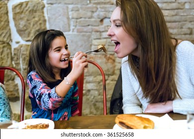 Portrait Of Happy Young Family Having Breakfast In The Cafe.