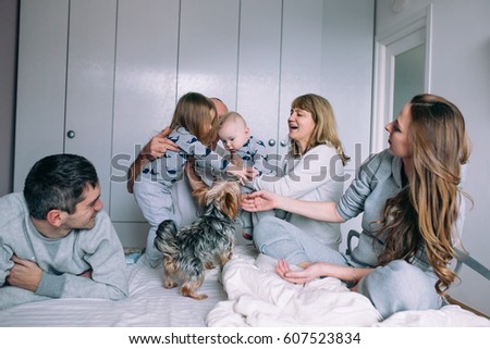 Relaxed mother and sons playing over the bed