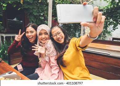 portrait of happy young girl friend taking selfie together in cafe - Powered by Shutterstock