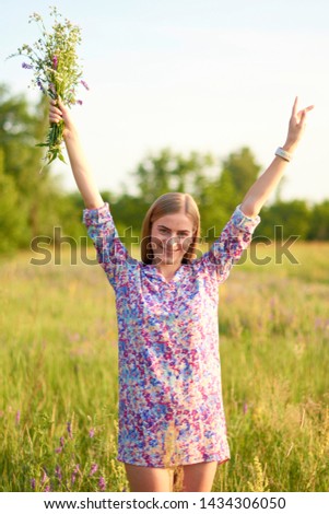 Portrait of a happy young girl on a background of flowering field