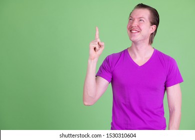 Portrait of happy young handsome man thinking and pointing up - Powered by Shutterstock