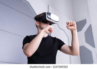 Portrait Of Happy Young Handsome Man Guy Using, Wearing A Modern Device Virtual Reality Headset Mask Or 3D, AR, VR Glasses, Playing The Game, Fighting. People And Technology Metaverse Concept.