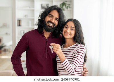 Portrait of happy young indian couple beautiful woman and man hugging and showing key from house, their new apartment, smiling at camera. Millennial family moving to own home. Mortgage, relocation - Powered by Shutterstock