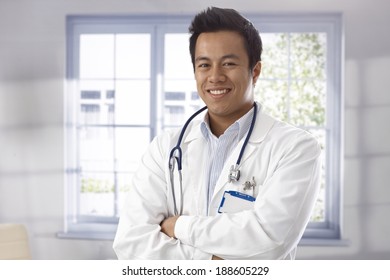 Portrait Of Happy Young Male Doctor Standing Arms Crossed, Looking At Camera.