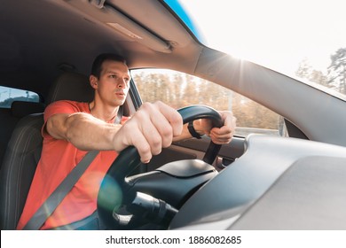 Portrait Of Happy Young Man Enjoying Fast Driving A Car. Inside Front View.