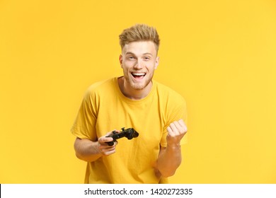 Portrait of happy young man playing video games on color background - Shutterstock ID 1420272335