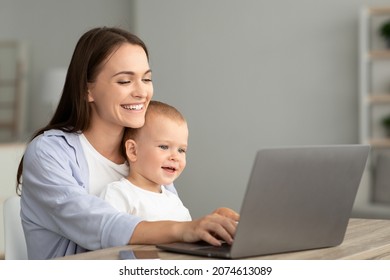 Portrait Of Happy Young Mother With Little Baby On Hands Using Laptop At Home Together, Smiling Millennial Mom Browsing Internet On Computer While Spending Time With Her Toddler Son, Copy Space