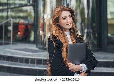 Portrait Of Happy Young Office Assistant Holding Laptop While Waiting For Her Colleagues In Front Of The Office Building. Feeling Funny And Happy. People