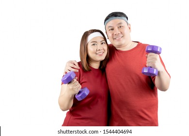 Portrait Of Happy Young Overweight Asian Couple Smiling And Exercising With Dumbbells Together Isolated On White Background With Copy Space. Healthy Lifestyle, Body Shape And Sport Concept.