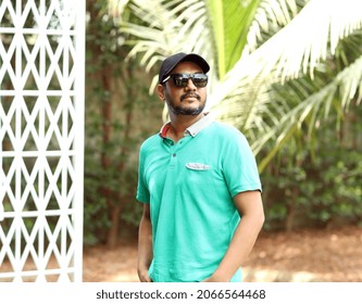 Portrait Of A Happy Young Pakistani Man Outside Setting Standing And Thinking In A Park In Karachi, Pakistan