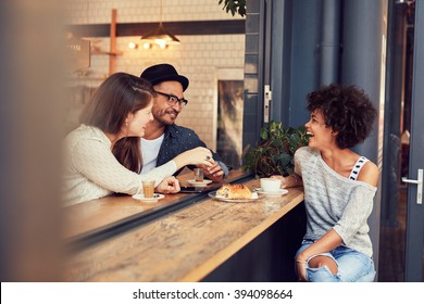 Portrait Of Happy Young People Sitting Together At A Cafe Having Some Food And Coffee. Group Of Friends Meeting In A Coffee Shop.