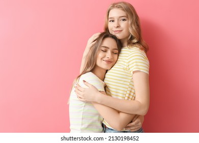 Portrait of happy young sisters on color background - Shutterstock ID 2130198452