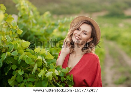 Portrait of a happy young woman 30-33 years old in the summer in the vineyards