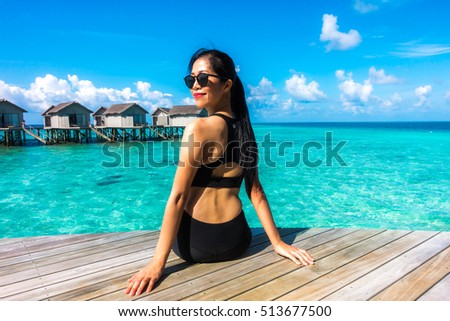 Portrait of happy young woman at beautiful water villa at Maldives island. Travel and Vacation. Outdoor shot