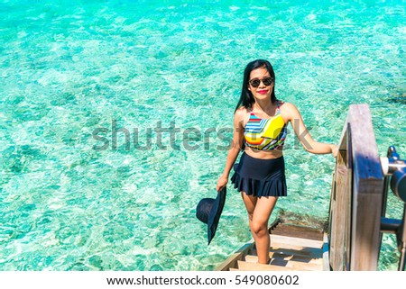 Portrait of happy young woman at beautiful water villa at Maldives island. Travel and Vacation. Outdoor shot