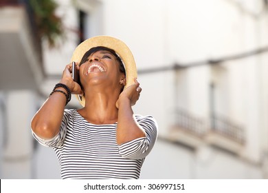 Portrait of a happy young woman laughing with cell phone