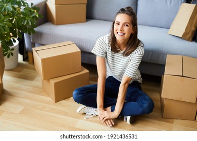 Portrait Of Happy Young Woman Moving In To New Apartment