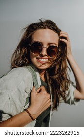 Portrait of happy young woman outdoor with backpack and sunglasses.