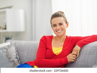 Portrait Of Happy Young Woman Sitting On Sofa