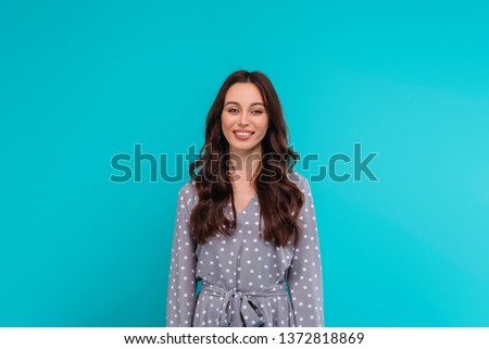 Portrait of a happy young woman smiling isolated over turquoise background