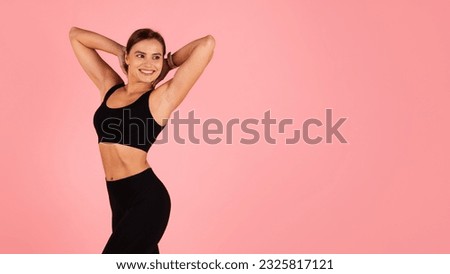 Portrait of happy young woman in sports outfit posing on pink studio background, smiling fit millennial female demonstrating perfect body shape, enjoying active lifestyle and fitness trainings