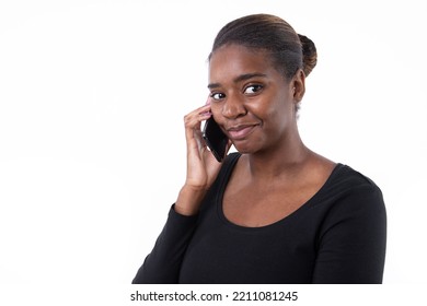 Portrait Of Happy Young Woman Talking On Mobile Phone. African American Lady Wearing Black Long Sleeve Looking At Camera And Smiling Against White Background. Mobile Technology Concept