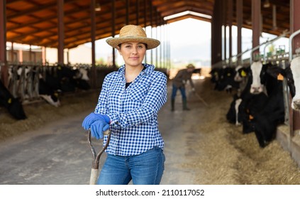 Portrait of a hardworking latin american young woman standing on a livestock farm with a working tool in her hand. ..Close-up portrait