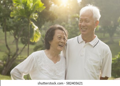 Portrait Of Healthy And Happy Asian Seniors Retiree Couple Having Fun At Outdoor Nature Park, Morning Beautiful Sunlight Background.