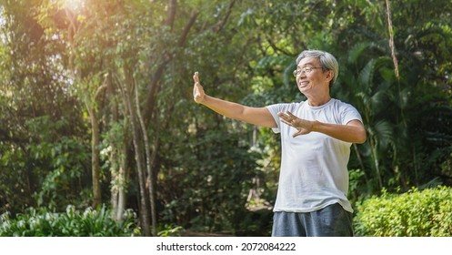 Portrait of healthy happy senior asian old man in the park outdoors exercise stretching his arms. Spring healthcare lifestyle grandfather retirement wellness healthy, Chinese old men concept  - Shutterstock ID 2072084222