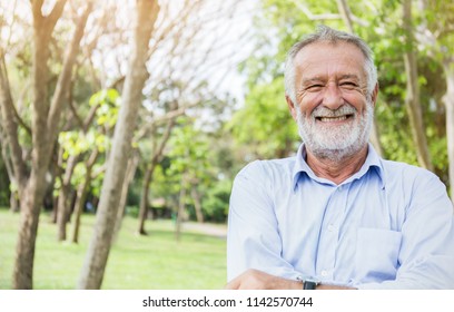 Portrait Of Healthy Happy Smile Senior Elderly Caucasian Old Man Grandfather In The Park Outdoors With Copy Space. Spring Autumn Golden Age Healthcare Cheerful Lifestyle Freedom Retirement Concept 