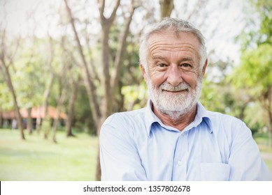 Portrait Of Healthy Happy Smile Senior Elderly Caucasian Old Man In The Park Outdoors With Copy Space. Spring Autumn Golden Age Healthcare Cheerful Lifestyle Freedom Retirement Concept 