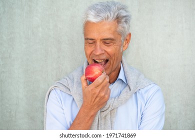 Portrait Healthy Older Man Eating Apple By Green Background 