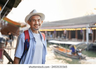 portrait healthy senior man standing and smiling at floating market in Thailand,elderly lifestyle,pensioner,retirement,travel,wellbeing - Powered by Shutterstock