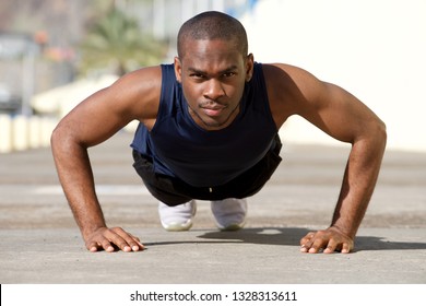 Portrait of healthy young black man doing pushups outside - Powered by Shutterstock