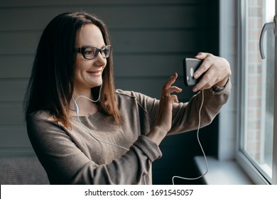 Portrait Of Healthy Young Brunette Woman Making Facetime Video Calling With Smartphone At Home, Using Zoom Meeting Online App, Social Distancing, Work From Home, Work Remotely Concept
