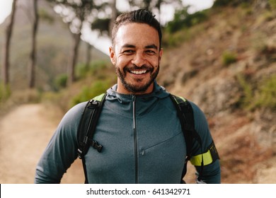 Portrait Of Healthy Young Caucasian Man Standing Outdoors And Smiling. Confident Young Male Runner On Country Road.