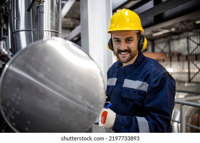 Portrait Of Heating Plant Worker Standing By Boiler And Checking Water Temperature.