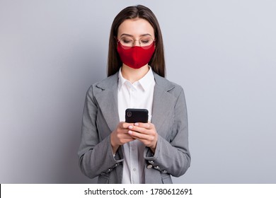 Portrait of her she attractive focused businesslady wearing safety cotton red reusable mask using device mers cov influenza prevention chatting remote work isolated grey color background - Powered by Shutterstock