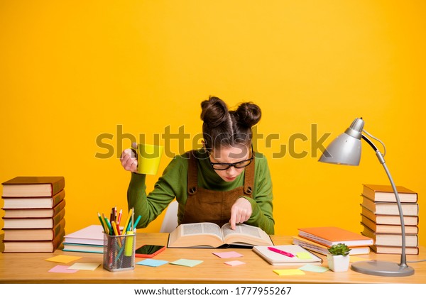 Portrait of her she attractive focused\
knowledgeable brainy diligent woman nerd reading book finding\
solution drinking caffeine isolated bright vivid shine vibrant\
yellow color\
background
