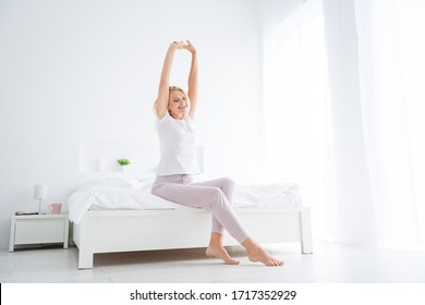 Portrait of her she nice attractive lovely dreamy sleepy cheerful cheery senior woman sitting in bed stretching waking up yoga asana inspiration in modern light white interior room flat apartment - Powered by Shutterstock